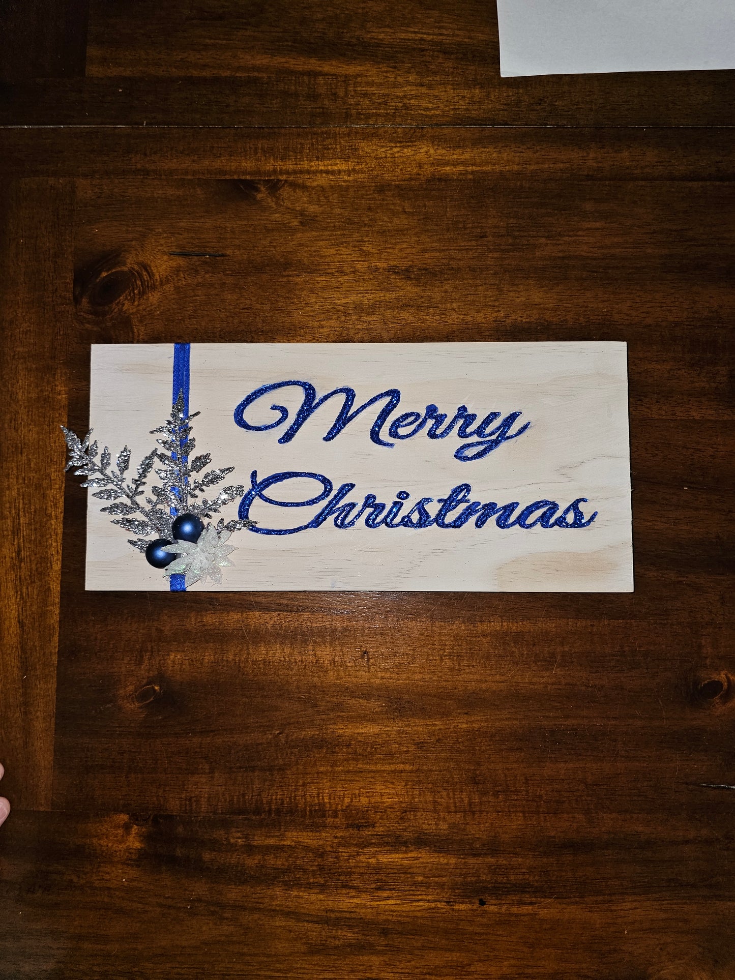 Merry Christmas sign, whitewashed with blue letters.